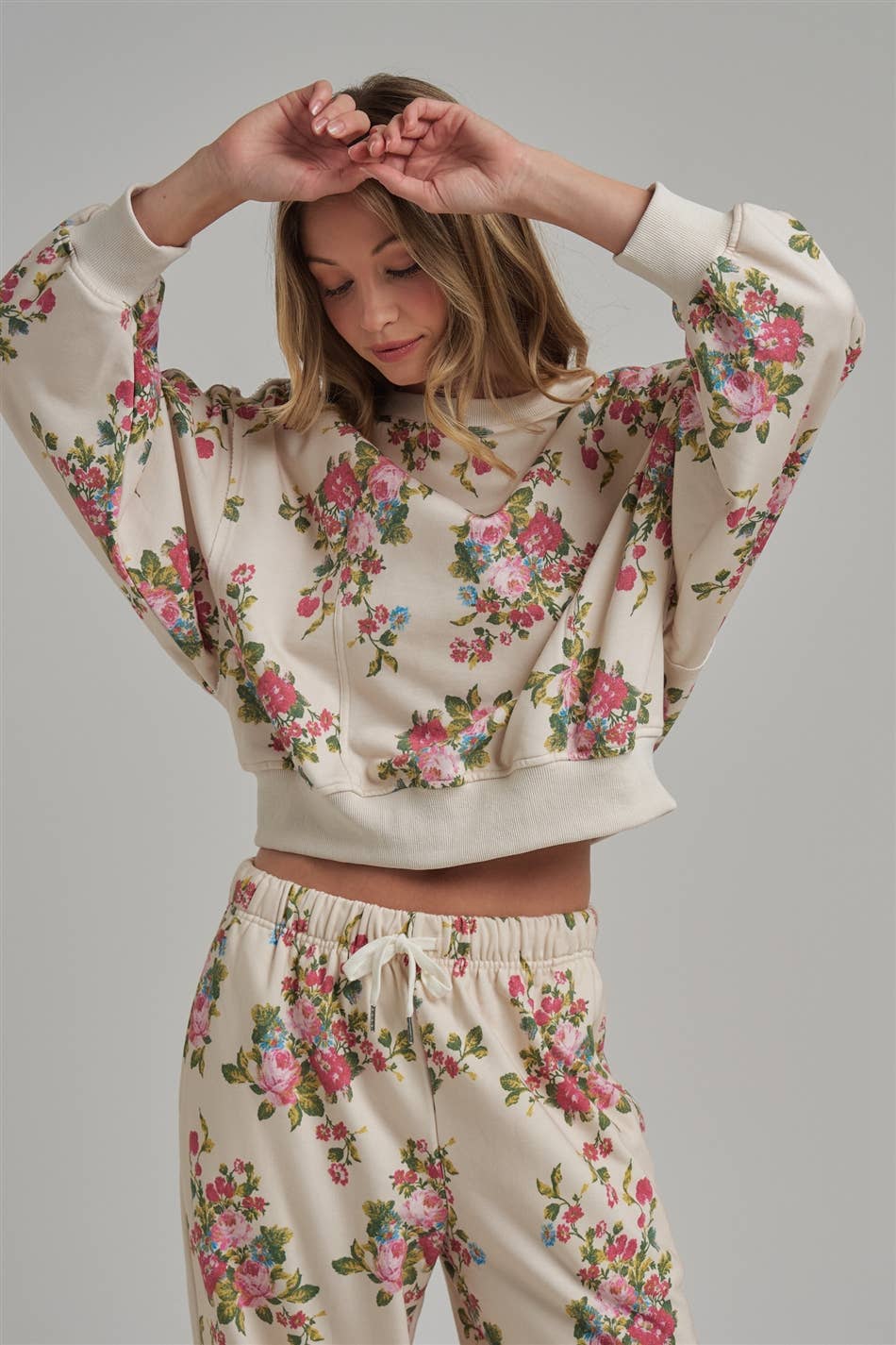 Woman wearing a floral pajama set against a gray background