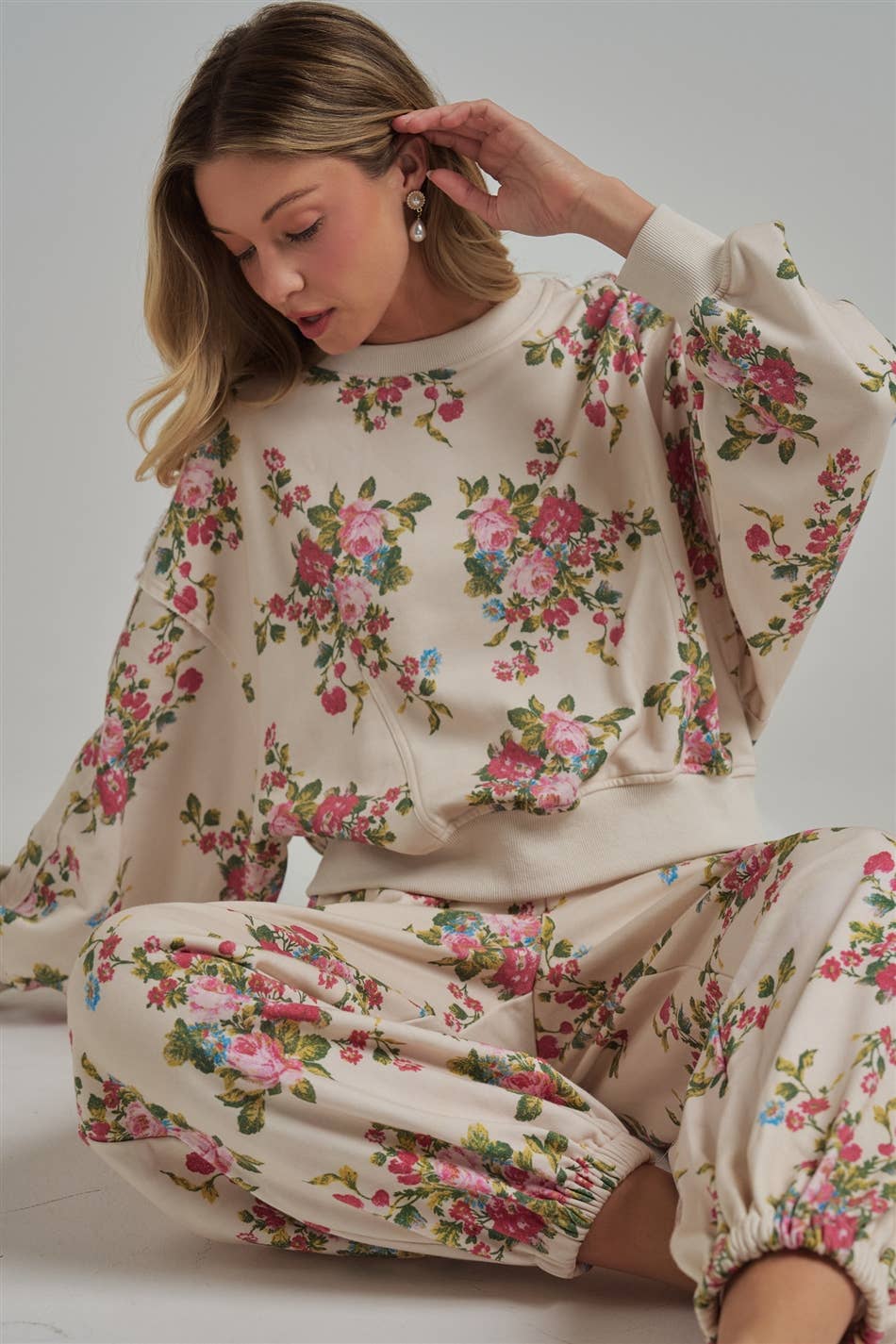 Woman model wearing a floral pajama set against a plain background